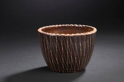 a close up of a wooden bowl on a black surface