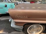 a brown car parked in a parking lot next to other cars