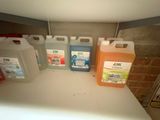 five bottles of liquid sitting on a counter next to each other
