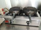two frying pans sitting on top of a stove