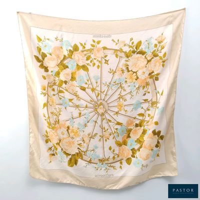a close up of a scarf hanging on a wall with flowers on it