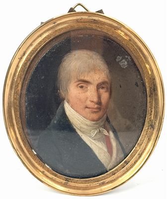 portrait d'un homme vêtu d'une veste bleue et d'une chemise blanche