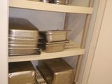 many pans and pans on the shelves in the kitchen