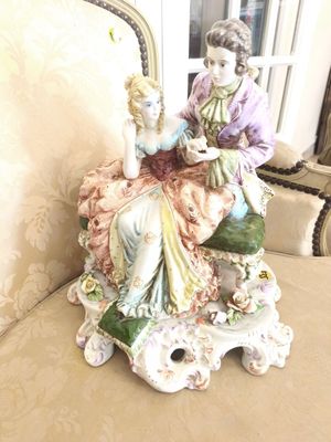 a figurine of a woman sitting on a chair