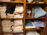 a cabinet full of folded clothes in a closet
