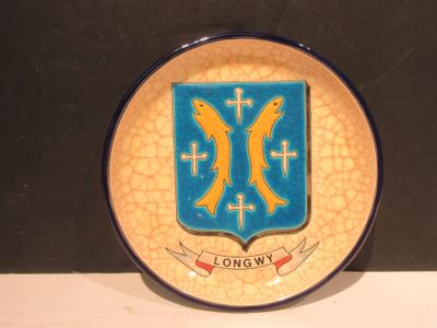une assiette sur laquelle figurent des armoiries et une croix