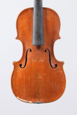an old violin sitting on top of a wooden stand