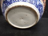 a blue and white vase sitting on a black surface