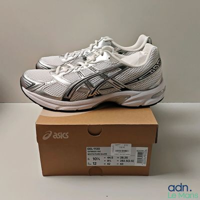 des chaussures de course Asics posées sur une boîte, elle-même posée sur une table