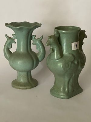 deux vases verts posés l'un à côté de l'autre sur une table