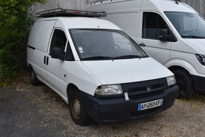 deux camionnettes blanches garées l'une à côté de l'autre dans un parking