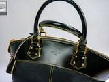 a black and gold purse sitting on a white surface