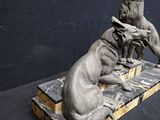 statue of two dogs sitting on top of a wooden block