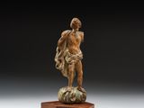 une statue en bronze représentant un homme debout au sommet d'un rocher
