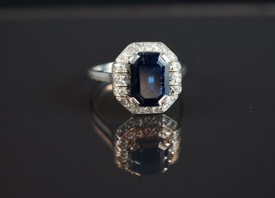 gros plan d'une bague en saphir bleu et diamant sur une surface noire