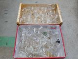 une boîte remplie de verres à vin vides posée par terre