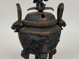 an antique bronze incense box with a statue on top of it