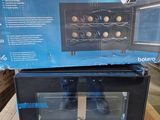 emballage d'un four électrique noir posé sur une boîte en carton