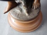 a bronze statue of a person sitting on top of a table