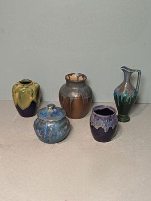 five different vases sitting on a table next to each other