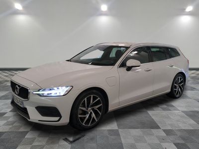 une Volvo break blanche garée sur un sol en carrelage à damier