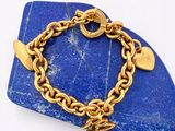 une photo d'un bracelet en or orné d'une breloque en forme de cœur