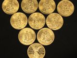six gold sovereigns are arranged in a triangle on a black surface