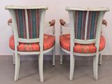 pair of antique painted chairs with upholstered seats in a white room
