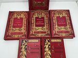 six livres rouges et dorés, ornés de bordures dorées