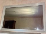 a mirror above a fireplace with a shelf underneath it