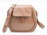 a tan leather cross body bag with a tassel on the front