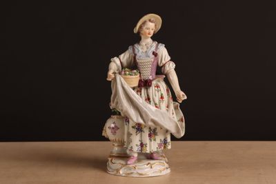 une image représentant une figurine de femme tenant un panier de fleurs