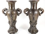 two vases that are sitting side by side on a white surface