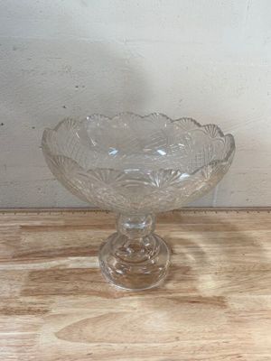 un saladier en verre posé sur une table en bois, avec un mur blanc en arrière-plan