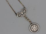 a close up of a necklace with a diamond on a chain