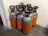 plusieurs bouteilles de gaz propane alignées contre un mur dans une pièce