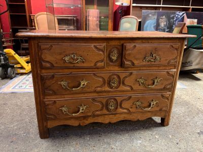 a wooden chest of drawers that is in a room