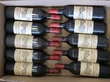 six bouteilles de vin dans un carton sur une table