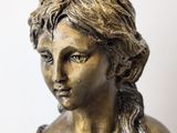 bronze statue of a woman holding a bird in her hand
