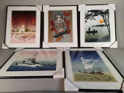 quatre photos encadrées représentant des oiseaux, un bateau et un hibou, posées sur une table