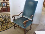 une chaise bleue dans une pièce où il y a un tapis au sol
