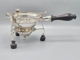 an antique silver plated coffee grinder with a black handle