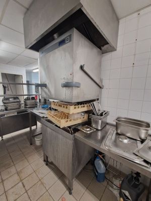 une cuisine équipée d'une cuisinière, d'un évier et d'autres appareils électroménagers
