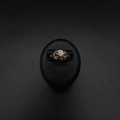 une bague en or posée sur une pierre noire