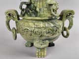 a large green vase with a statue on top of it