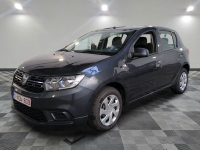 La Dacia grise est garée dans une pièce au sol carrelé en damier.