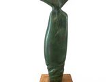 sculpture représentant un vase vert posé sur un socle en bois, sur fond blanc