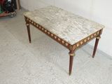 a marble top coffee table with wooden legs in a room