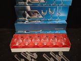 three boxes of wine glasses and a set of knives on a table
