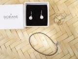 a white box with a pair of earrings and a bracelet